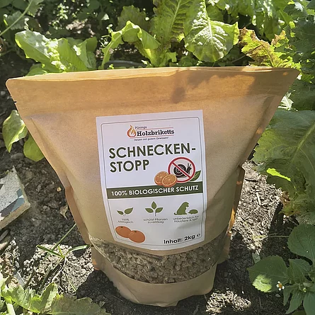 Pünings Schneckenstopp im 2-kg-Beutel zwischen Salatpflanzen